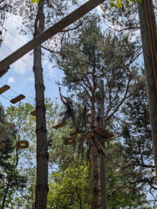 participant navigating an obstacle on the high ropes course