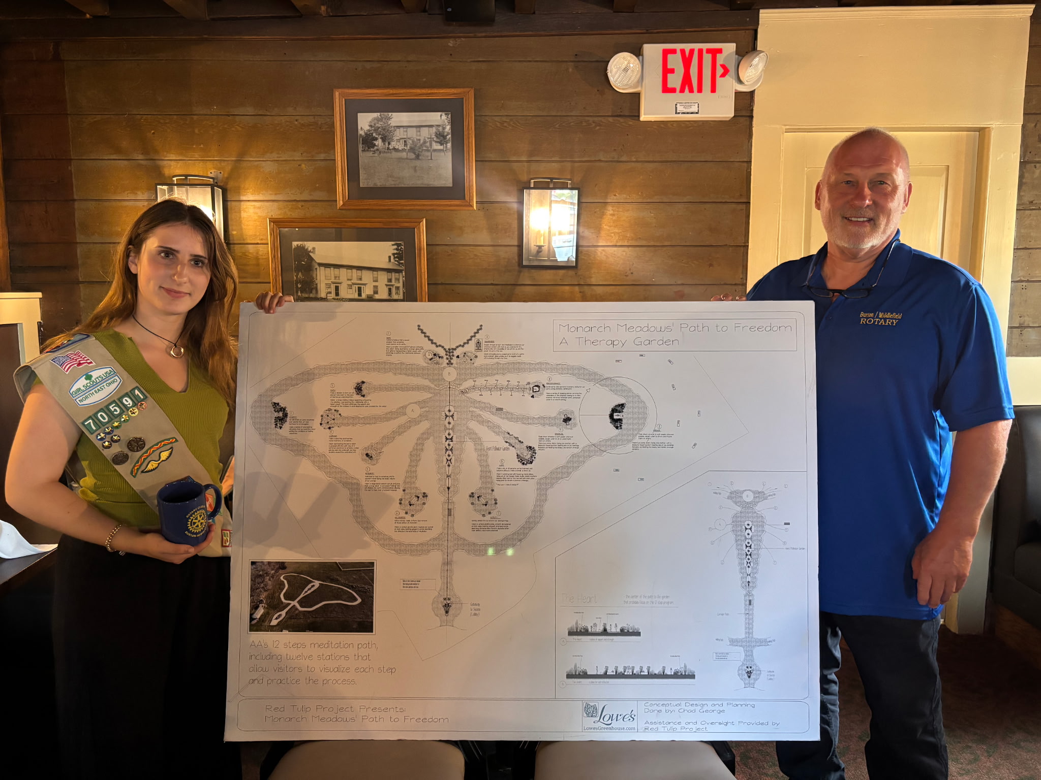 6267863059016119815.jpg Erin and Larry posing in front of her poster describing the garden project at a Rotary Club Meeting