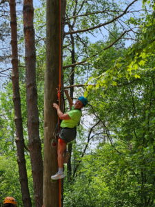 participant climbing the ladder to the high ropes course
